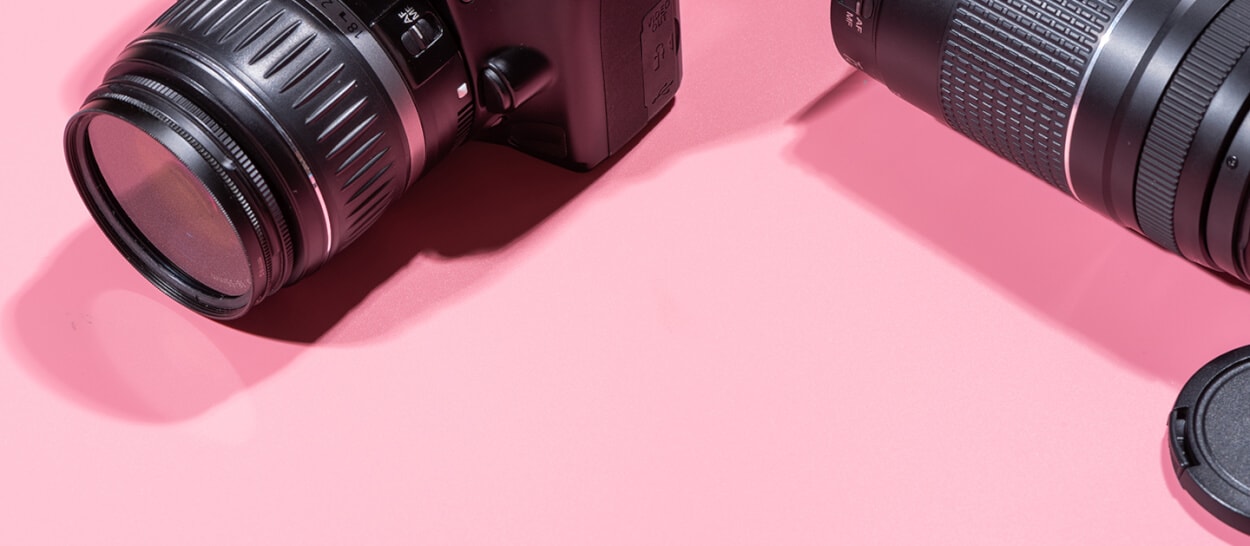 Professional camera and lens on pink backdrop for Thimble customer spotlight - Alex Gasaway