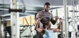 Personal trainer helping client at gym