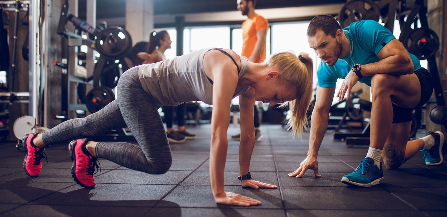personal trainer with client in gym