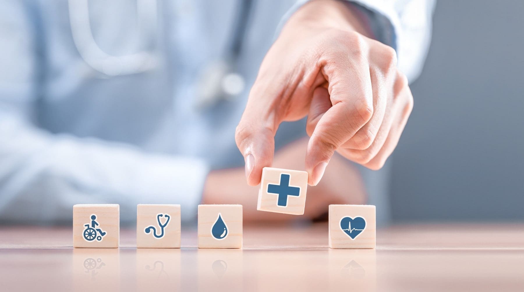Hand arranging wood block with healthcare medical icon