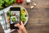 Food blogger using smartphone taking photo of beautiful mix fresh green salad