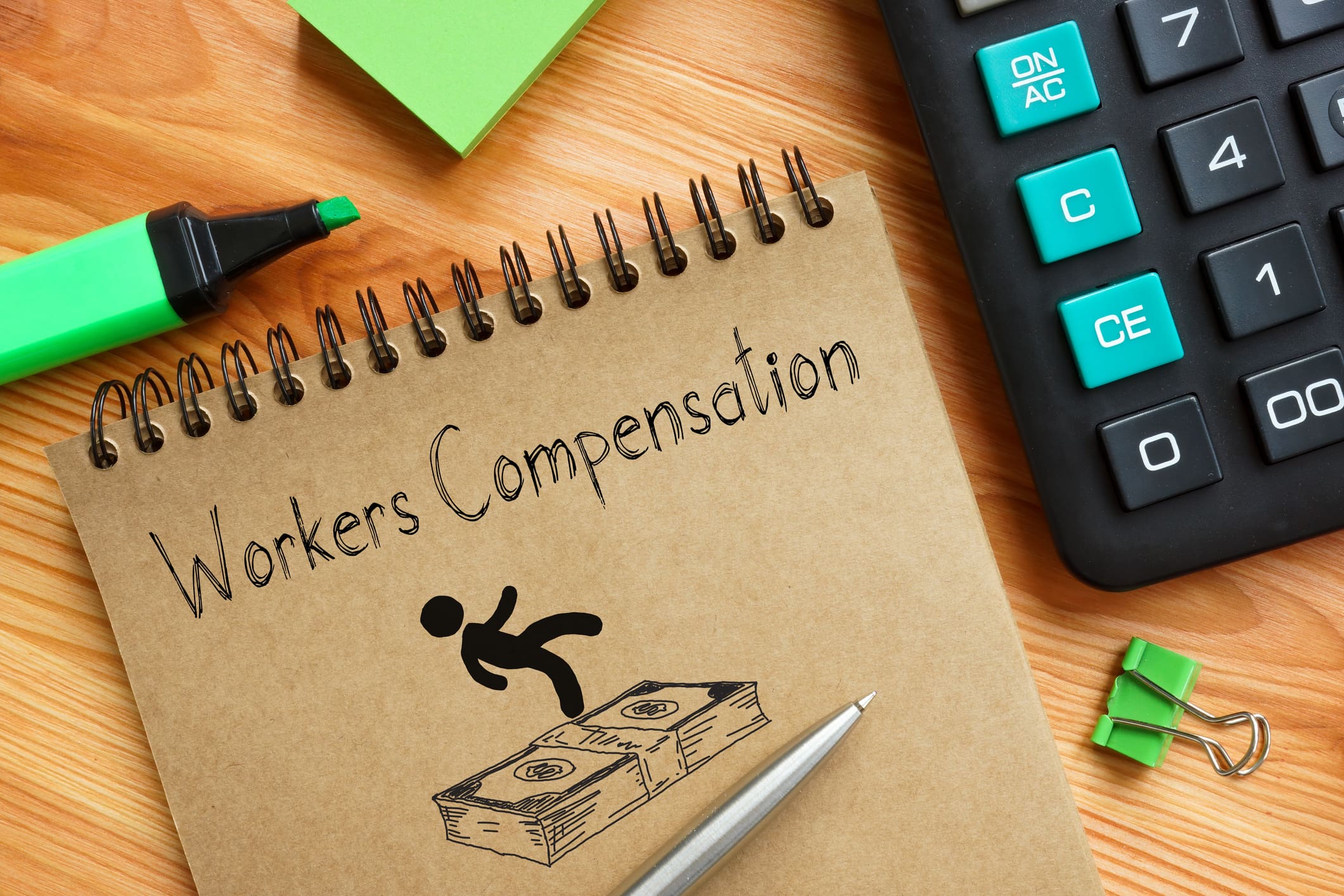 The text Workers Compensation written on a brown notepad.