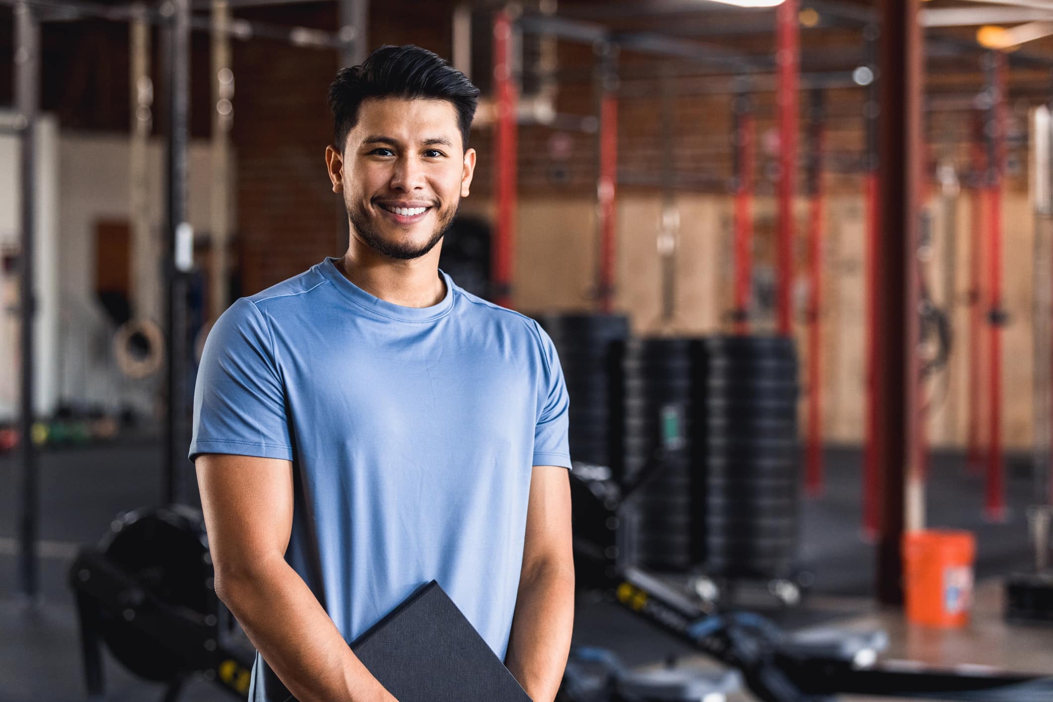 The owner of a cross training gym smiles confidently at the camera.
