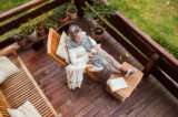 A top view of a retired woman with a book outdoors on a terrace in autumn.