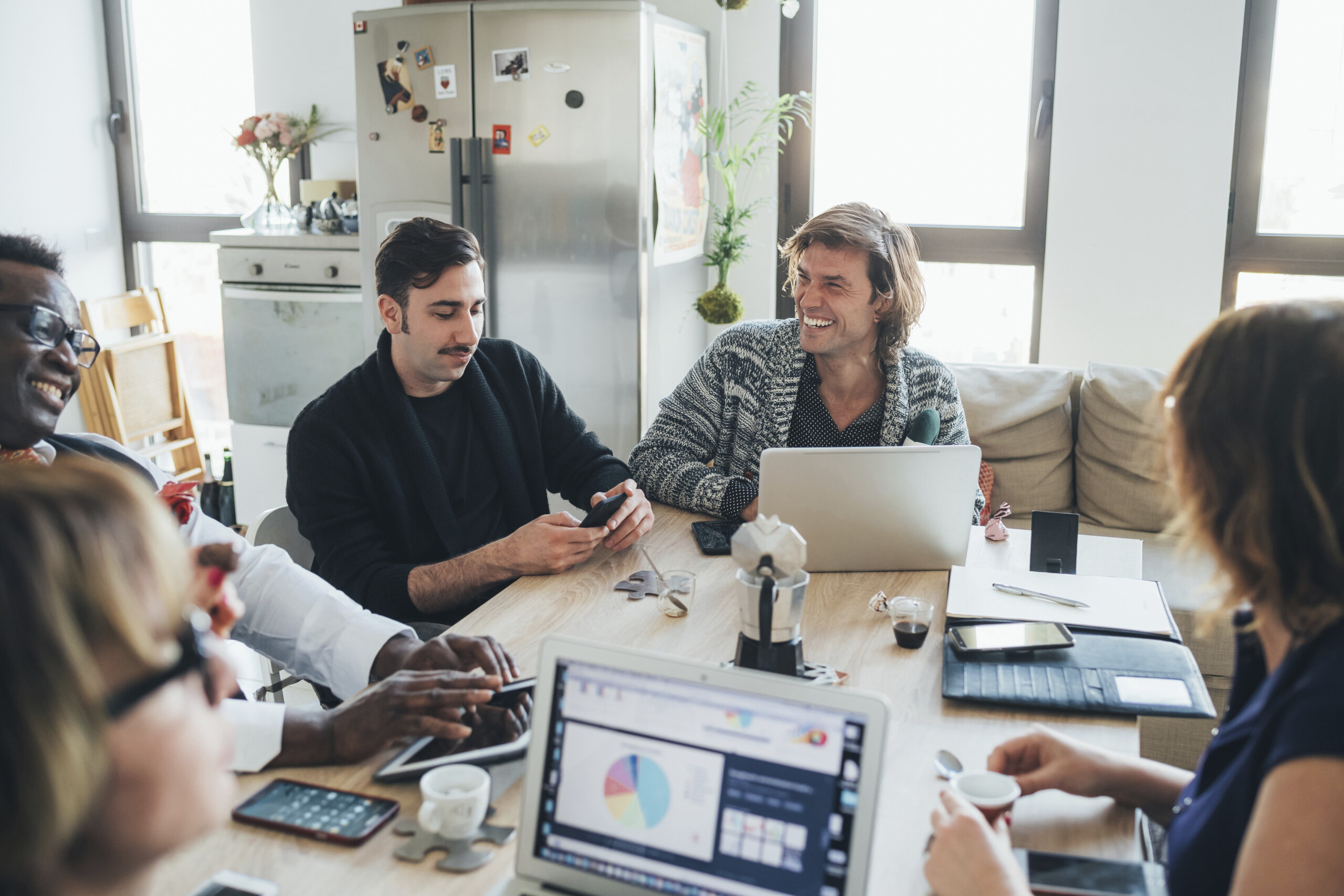 Smiling coworkers collaborate around a table